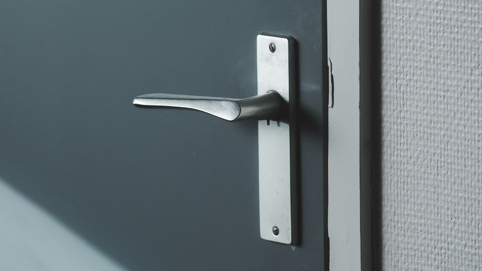 silver door lever on gray door