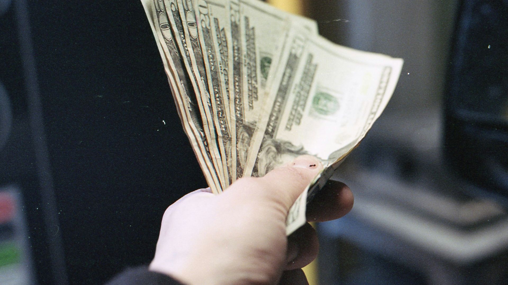 person holding fan of us dollar bill
