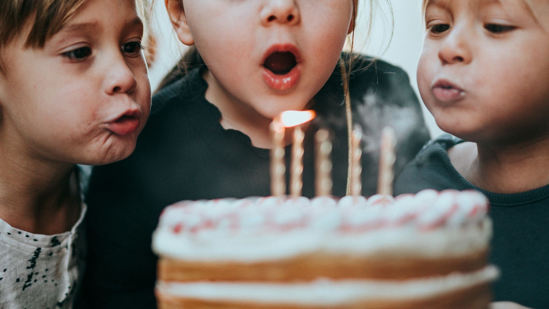 boy and girl blowing candles
