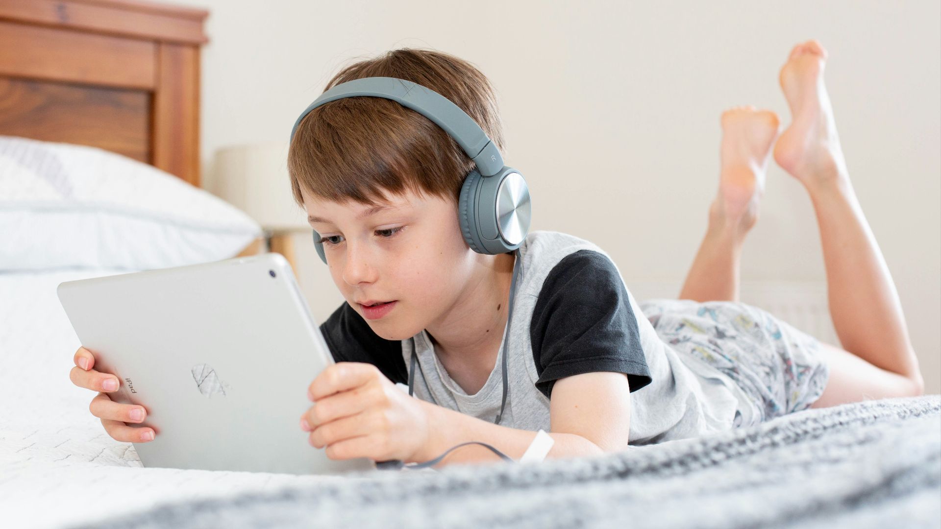 boy in black shirt using white laptop computer
