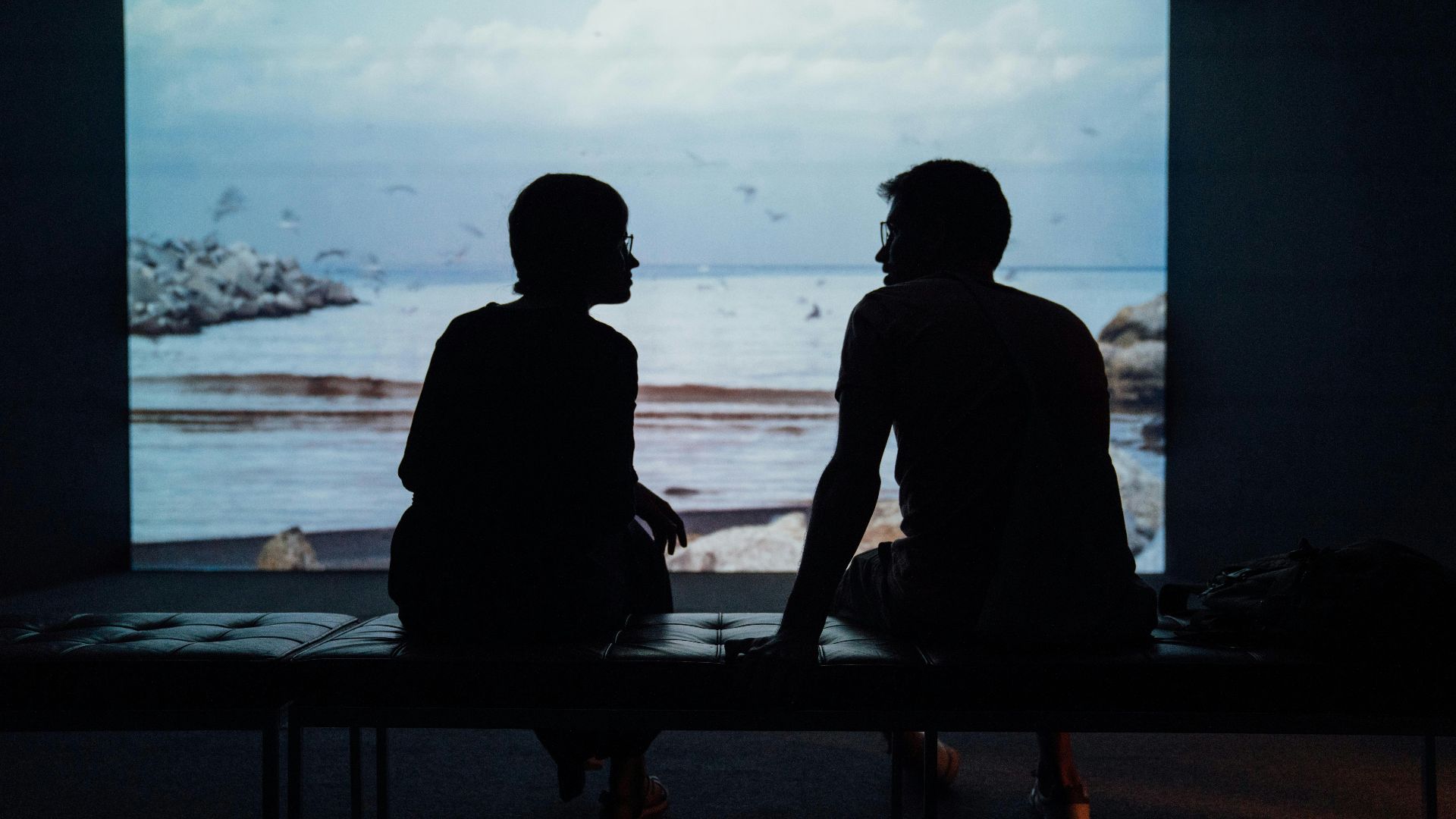 silhouette of man and woman sitting on ottoman