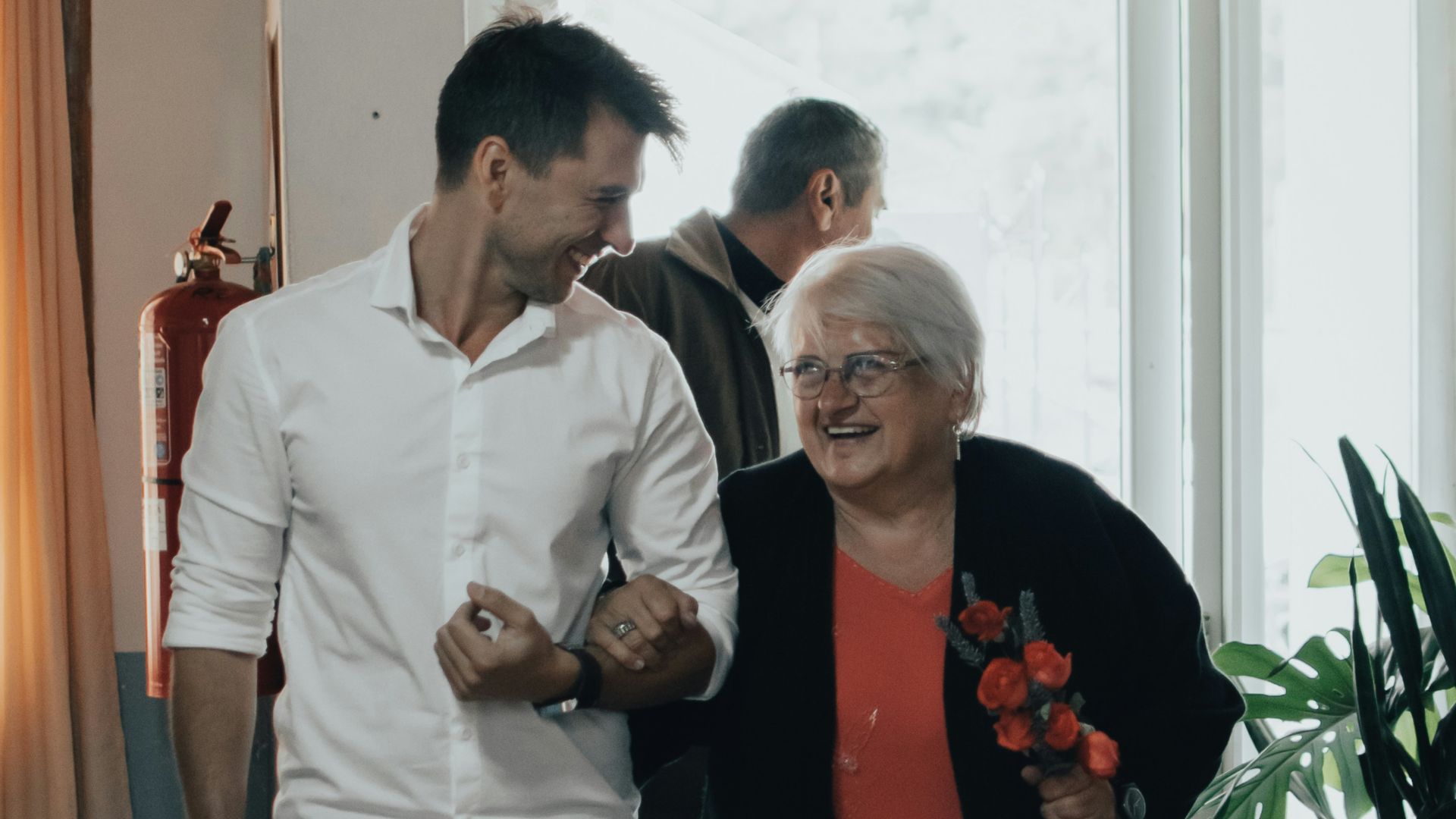 man in white dress shirt standing beside woman in red long sleeve shirt