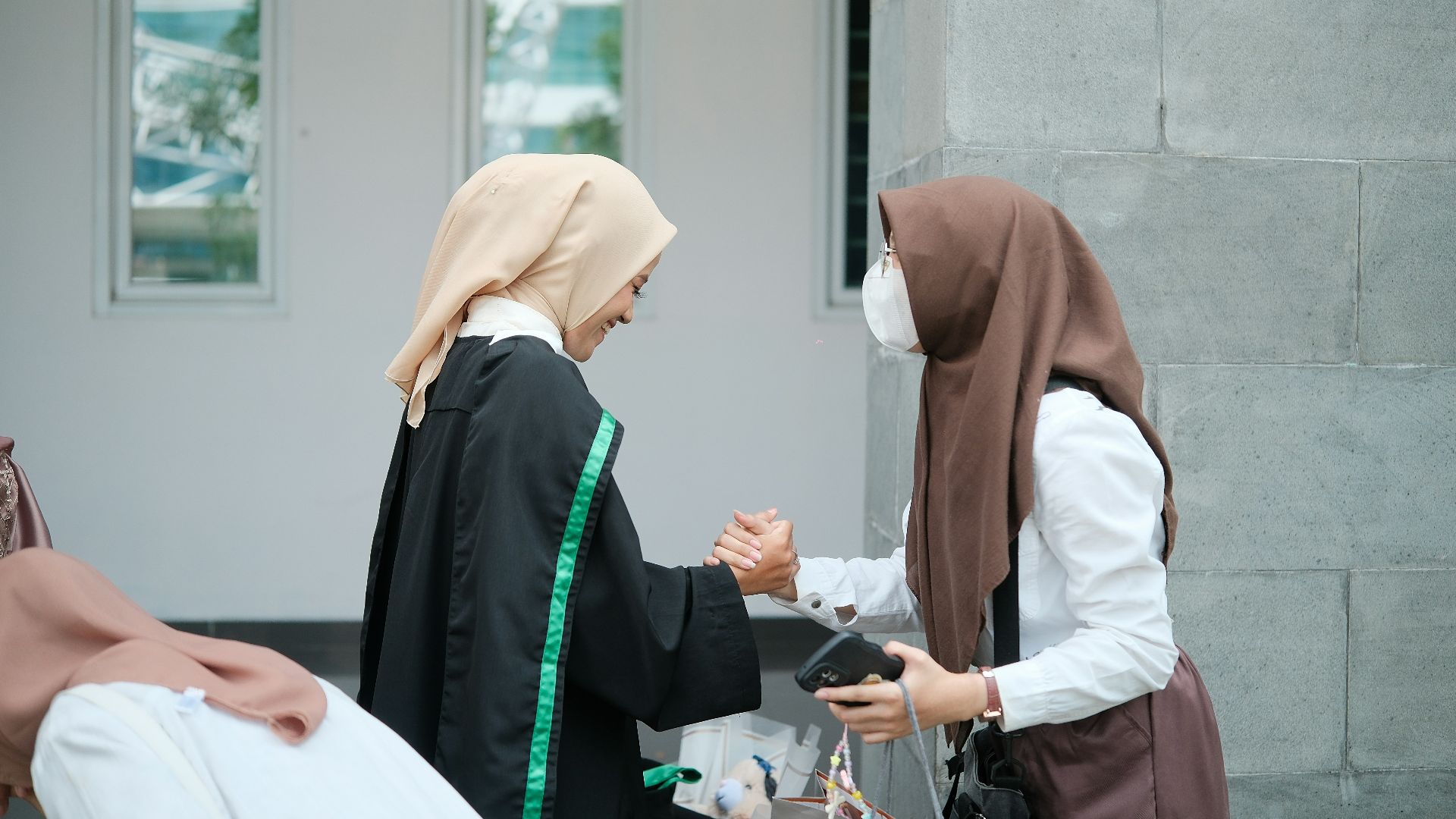 A group of women standing next to each other in front of a building