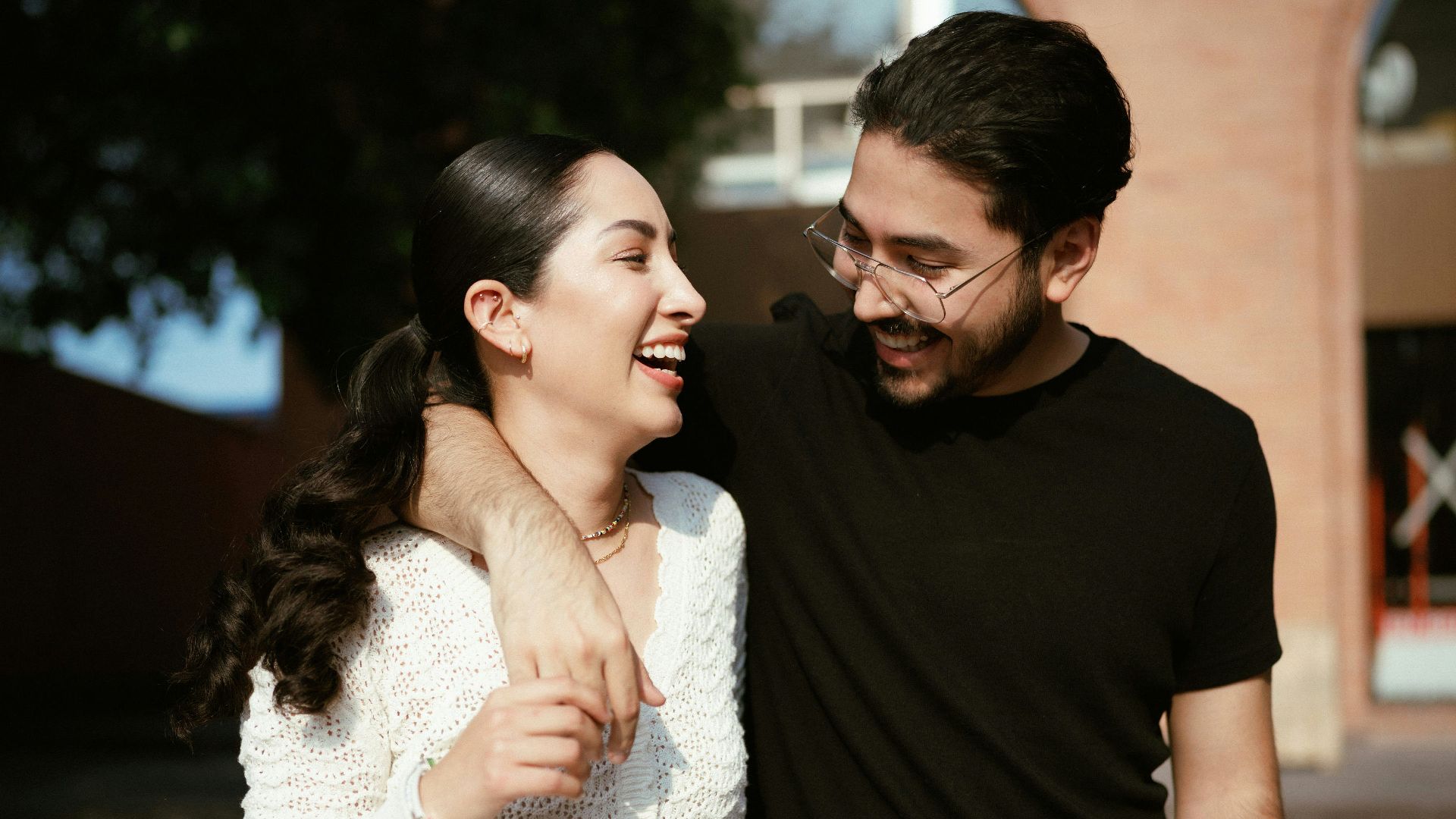 a man standing next to a woman near a tree