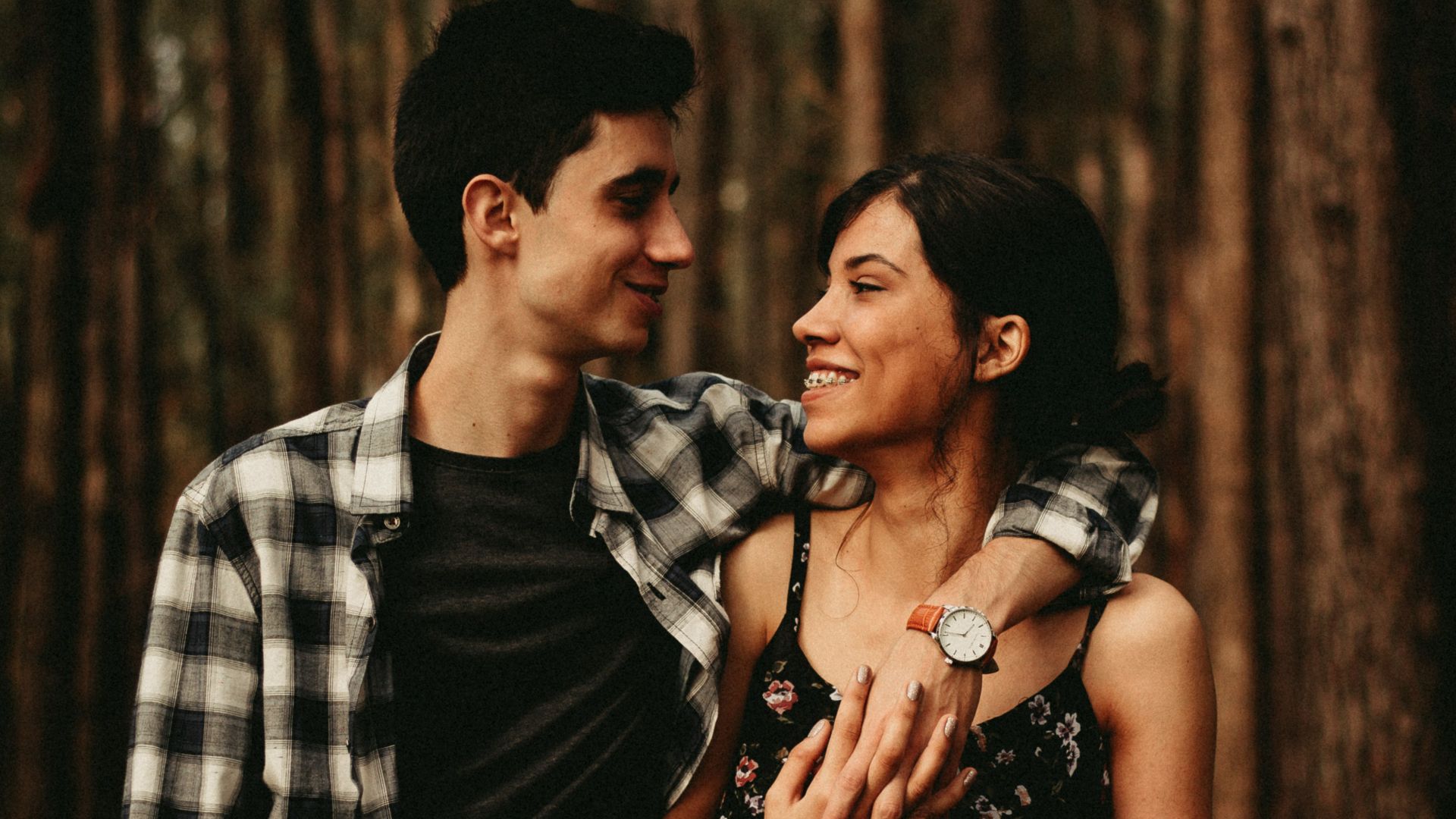 man wrapping arm on woman facing each other
