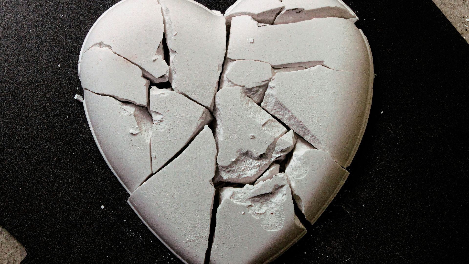 A broken heart shaped cookie sitting on top of a table