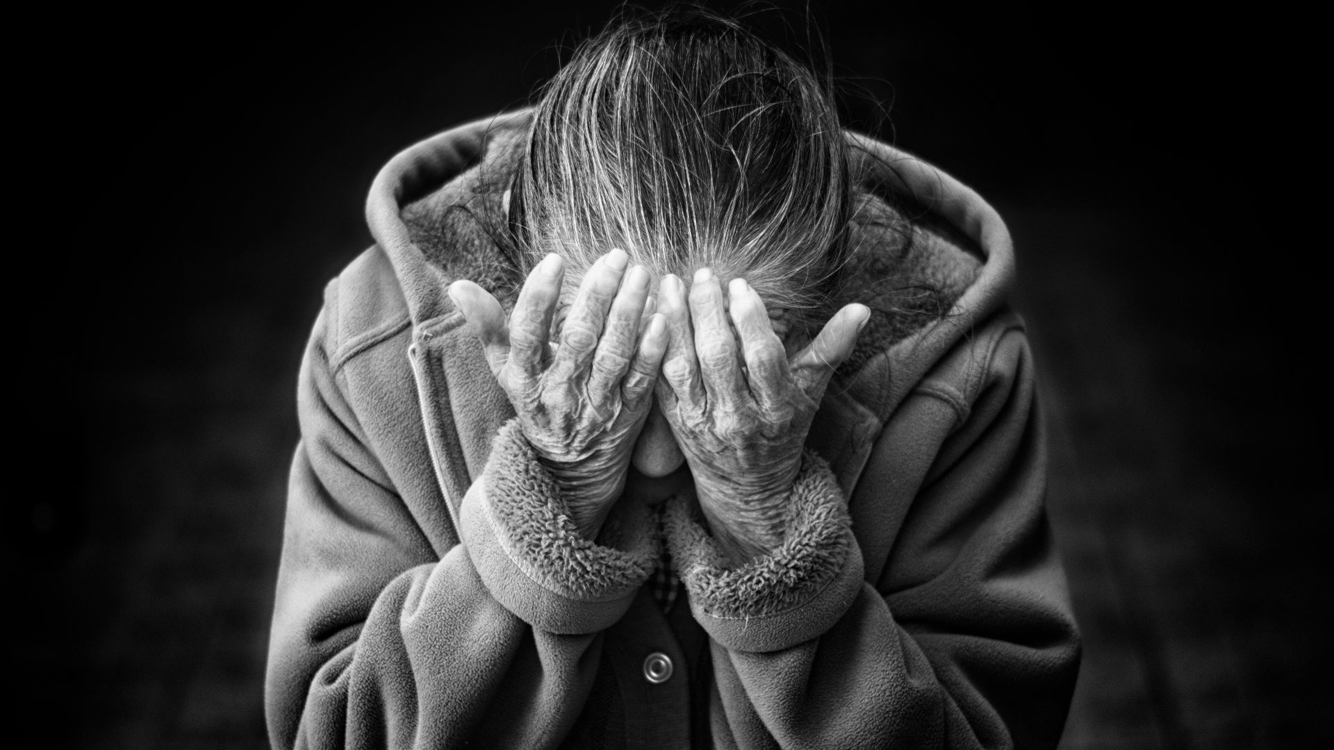 grayscale photography of person covering face