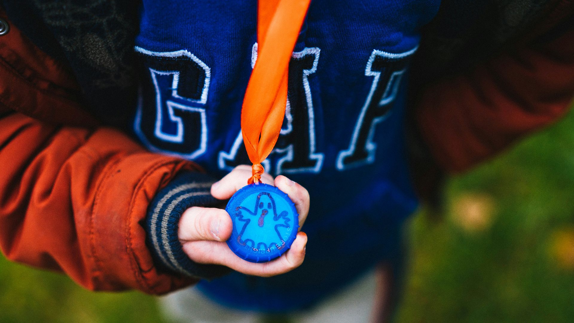 a young boy holding a medal in his hands