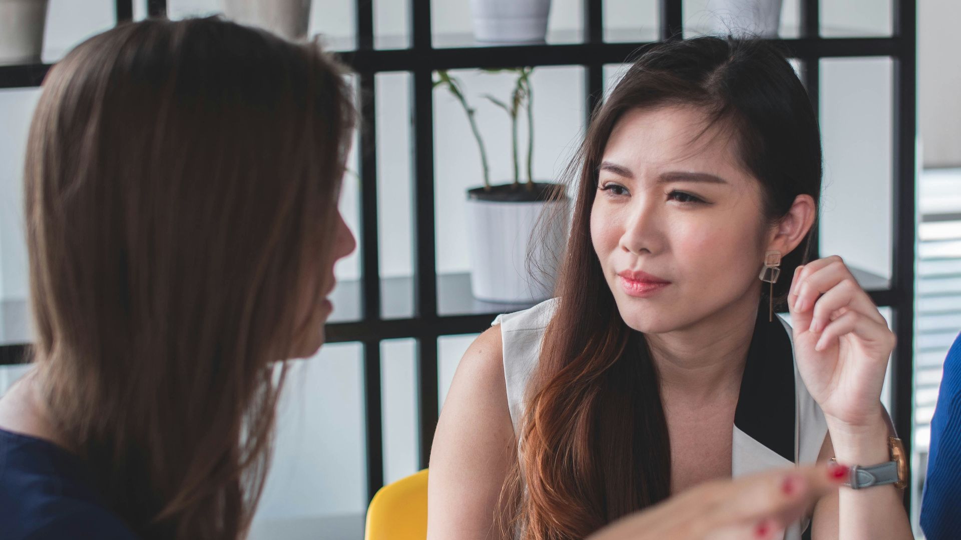 woman sitting on yellow armless chair near gray laptop computer