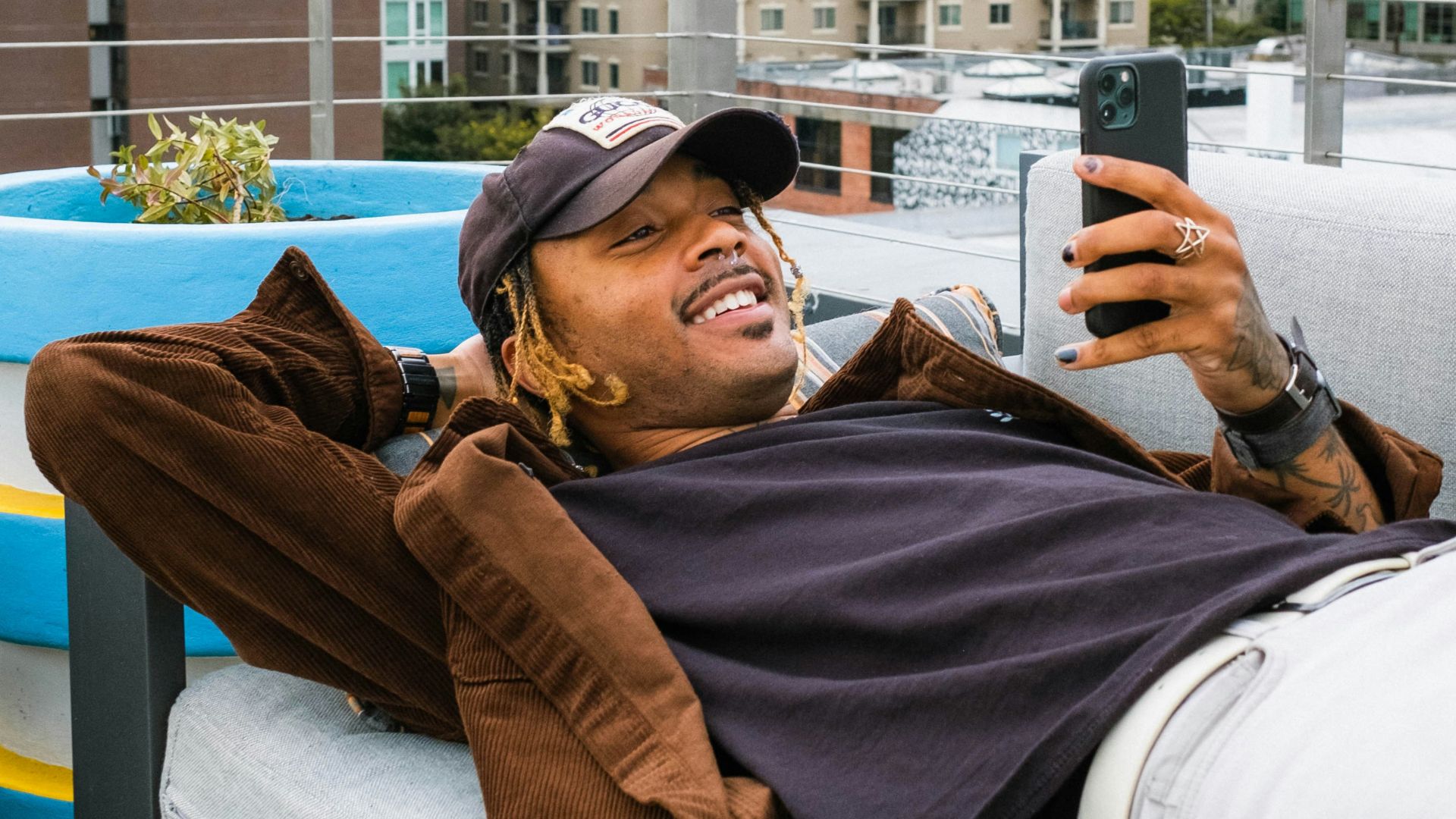 a man laying on a couch taking a picture of himself