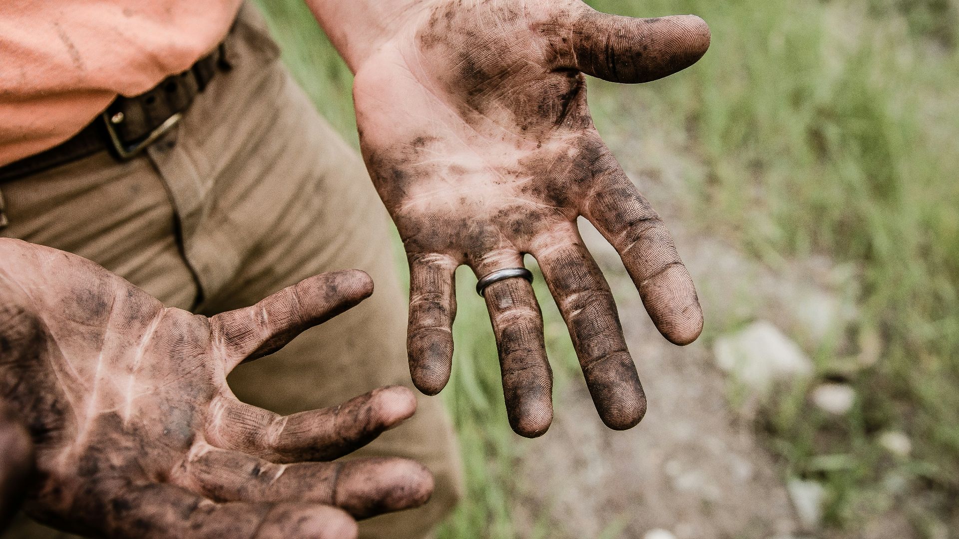 A man with his hands covered with mud