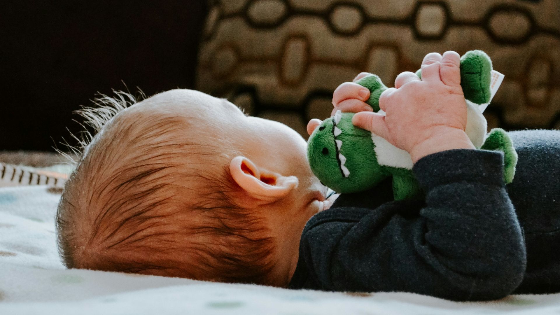 baby lying on white bed