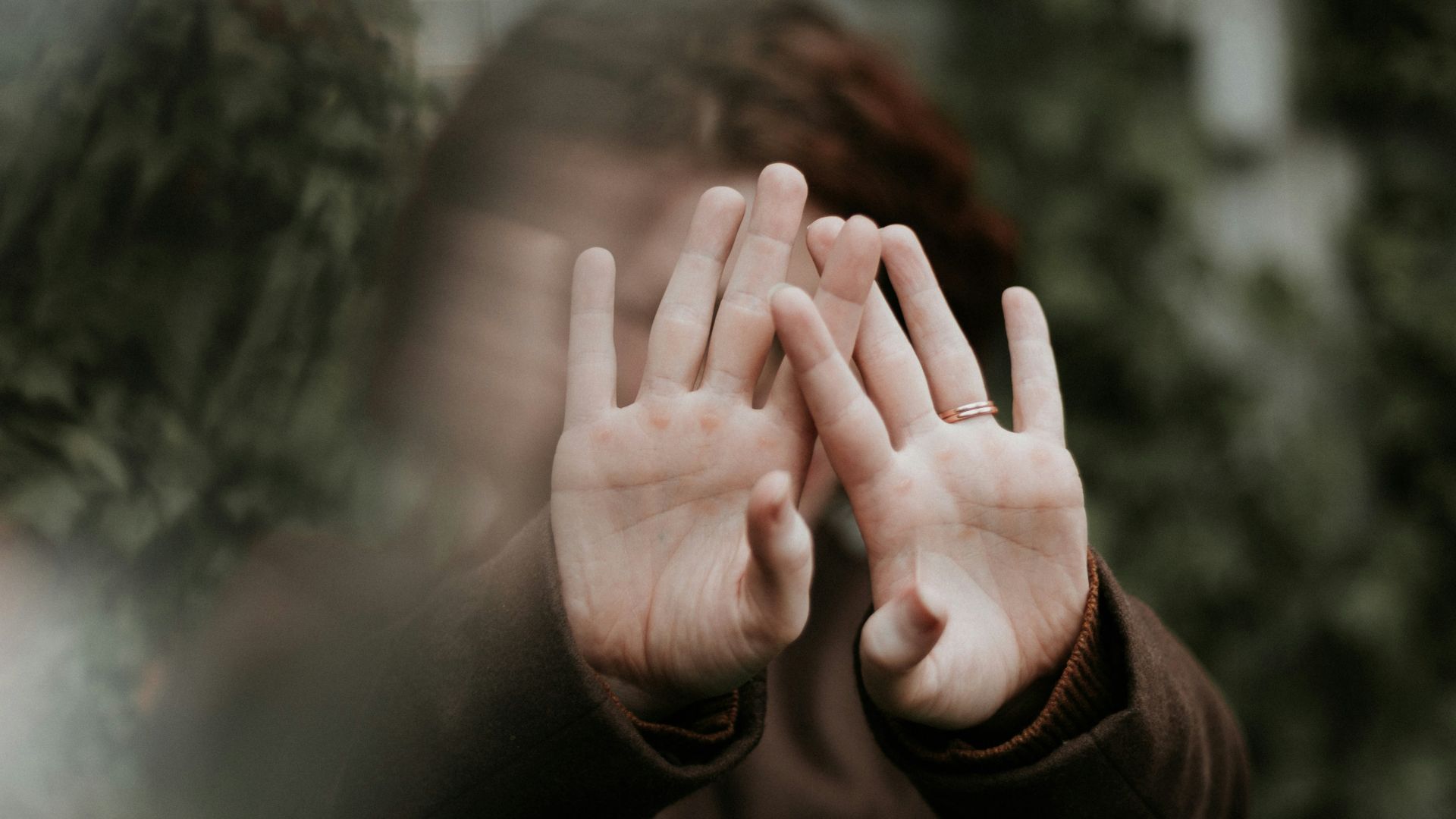 person in brown long sleeve shirt covering face with hand