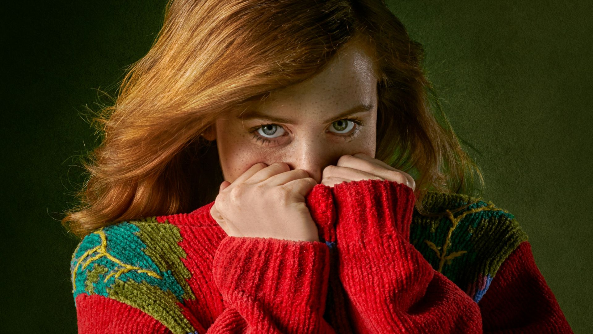 woman covering mouth with sweater