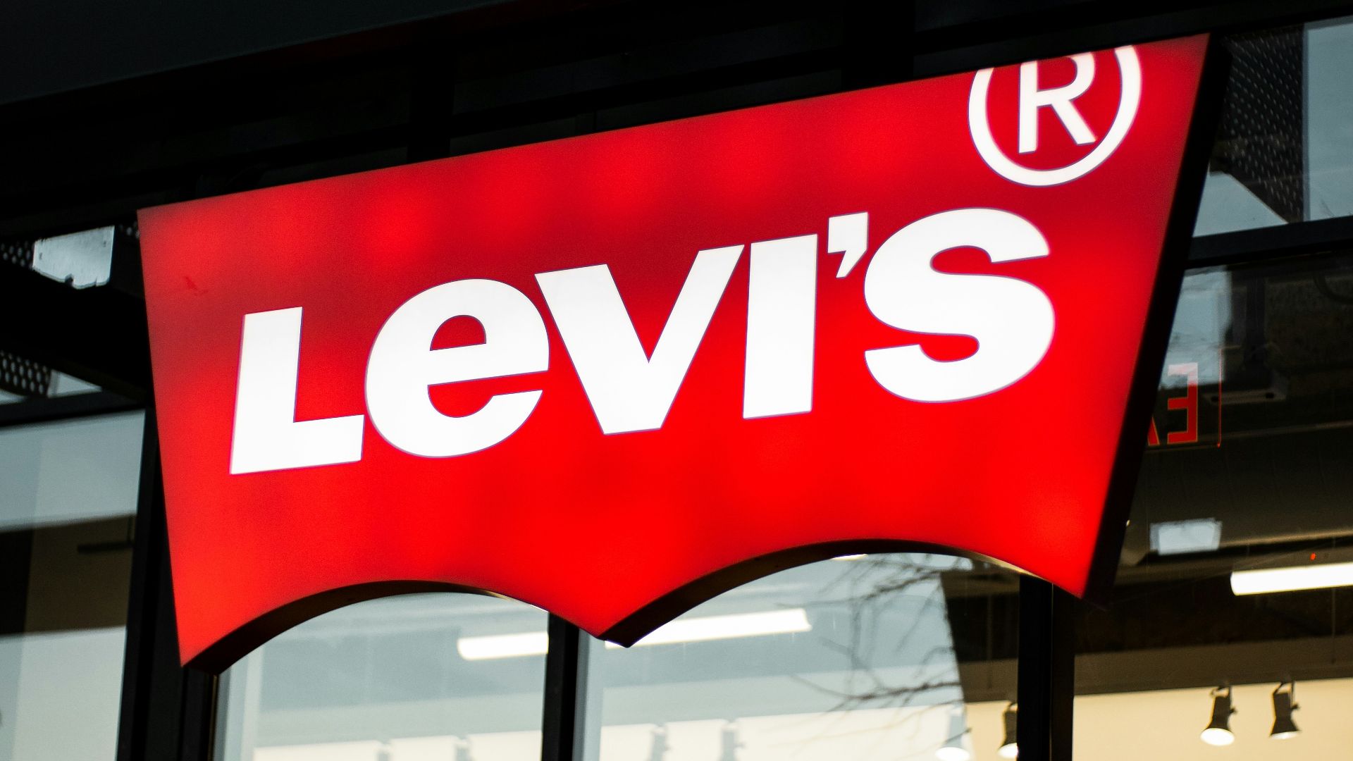 a levi's store sign is lit up at night