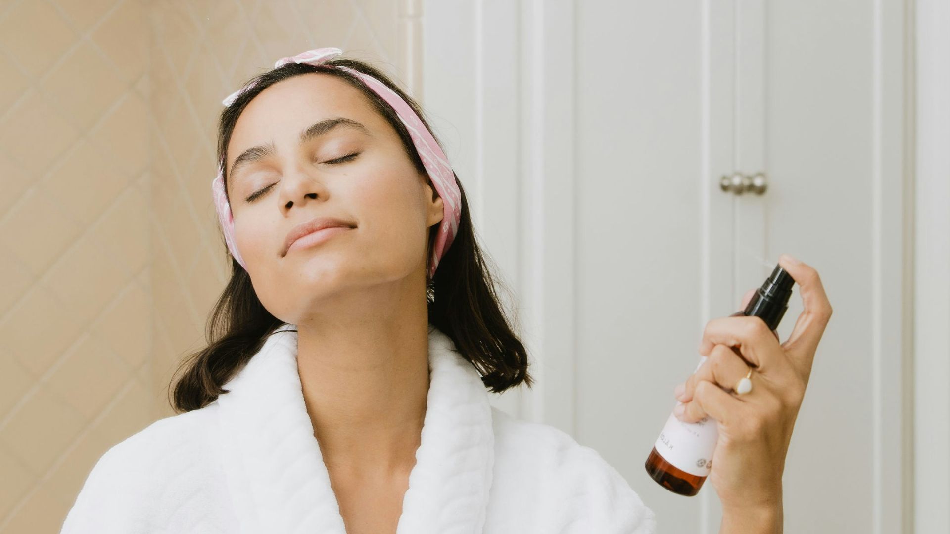woman in white bathrobe holding smartphone