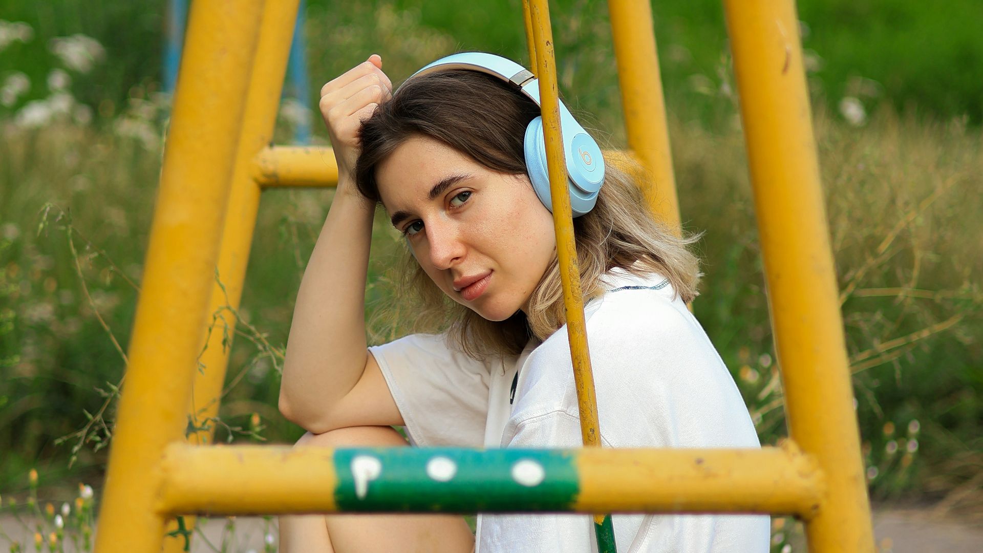a woman sitting on a swing in a park