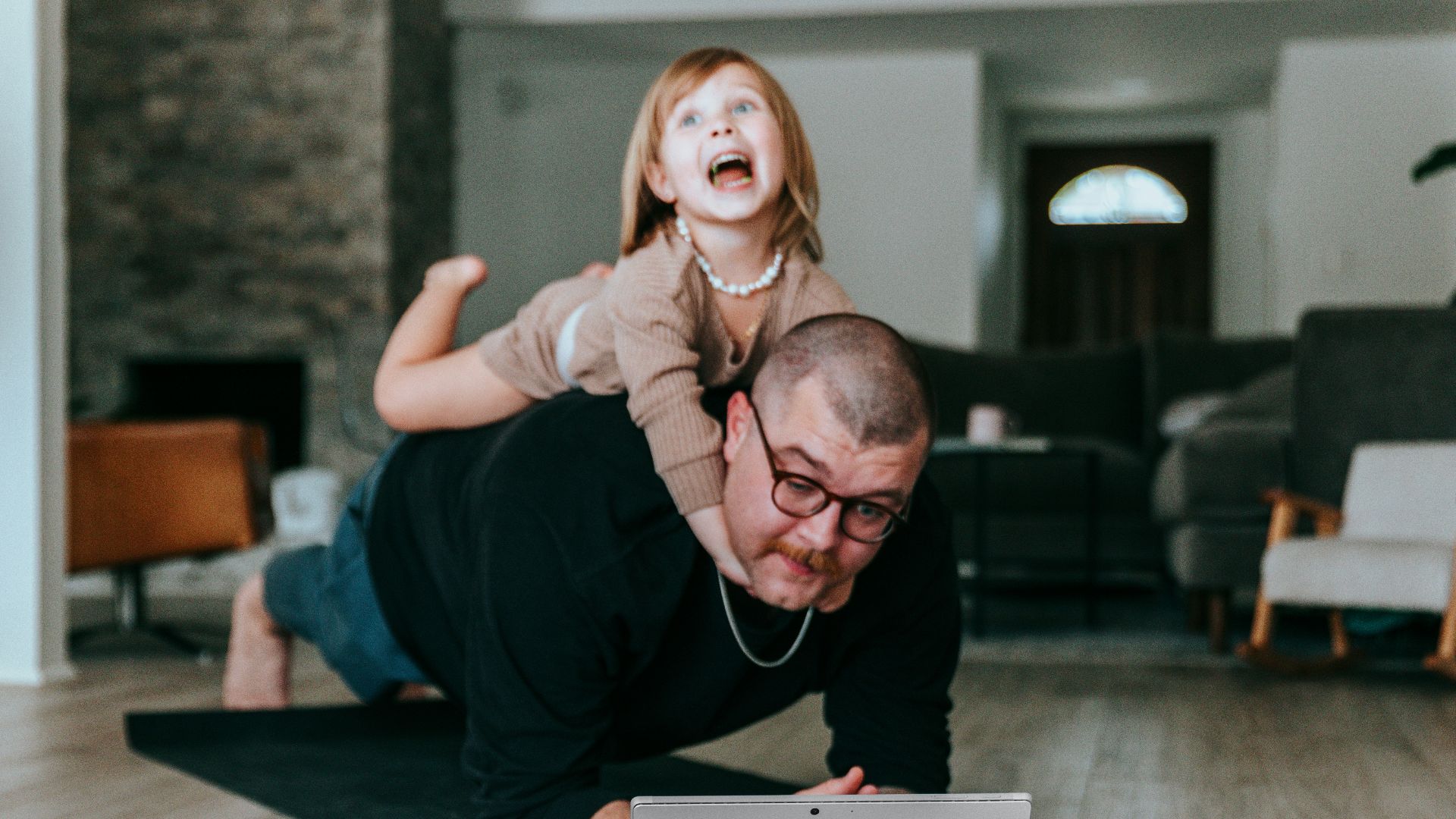 a man and a little girl playing with a laptop