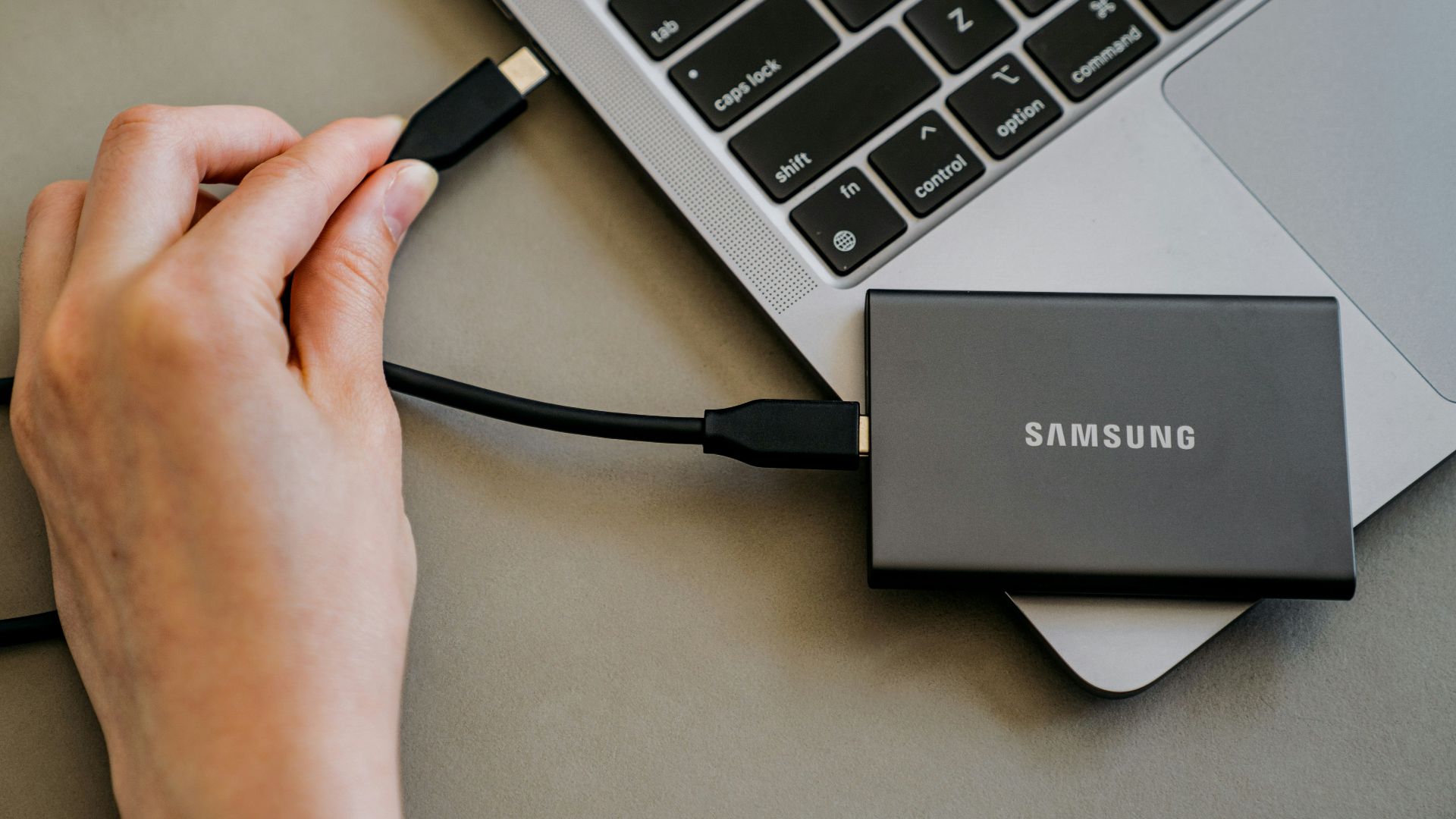 A person is plugging a charger into a laptop