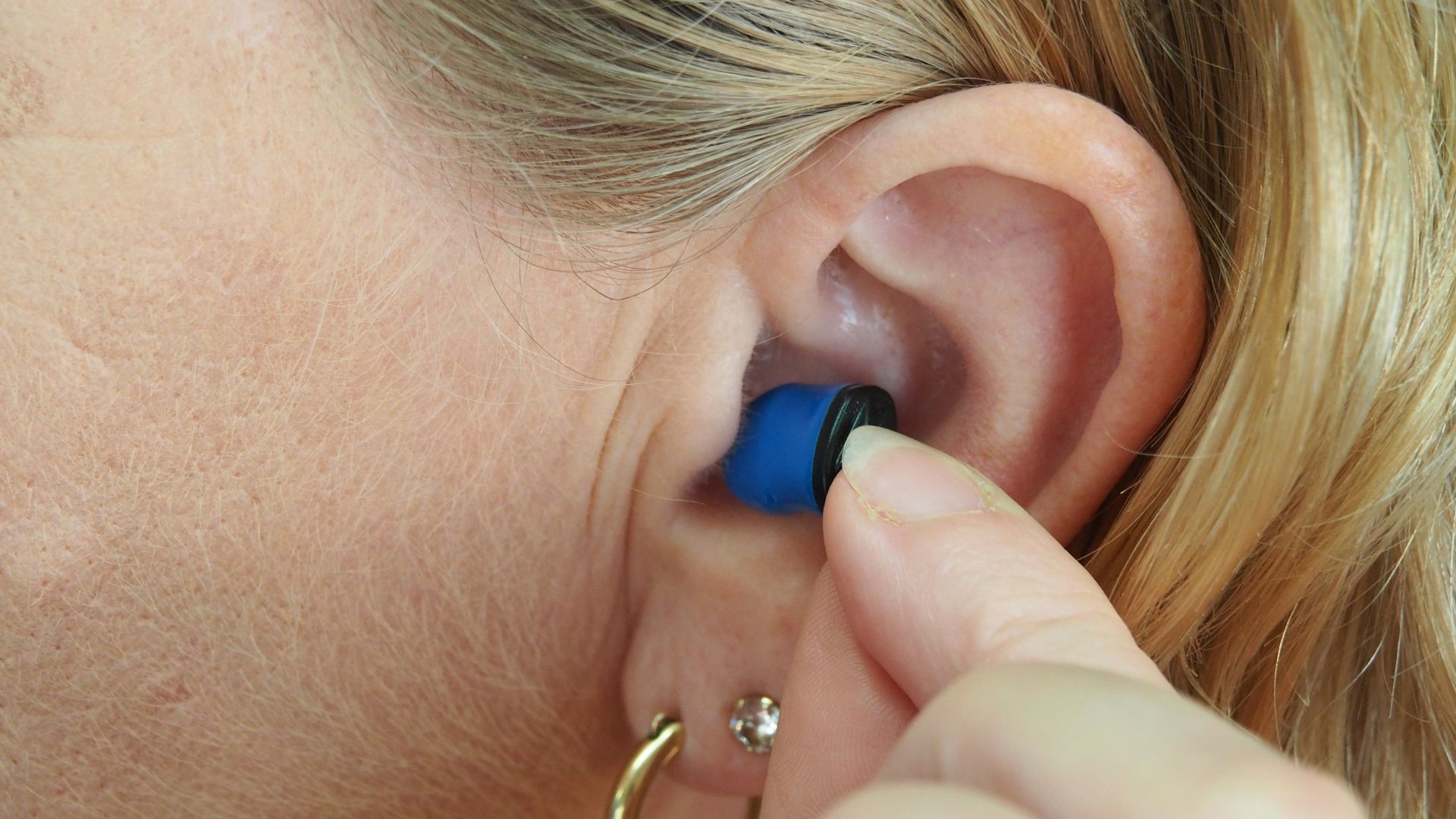 woman wearing blue stud earring