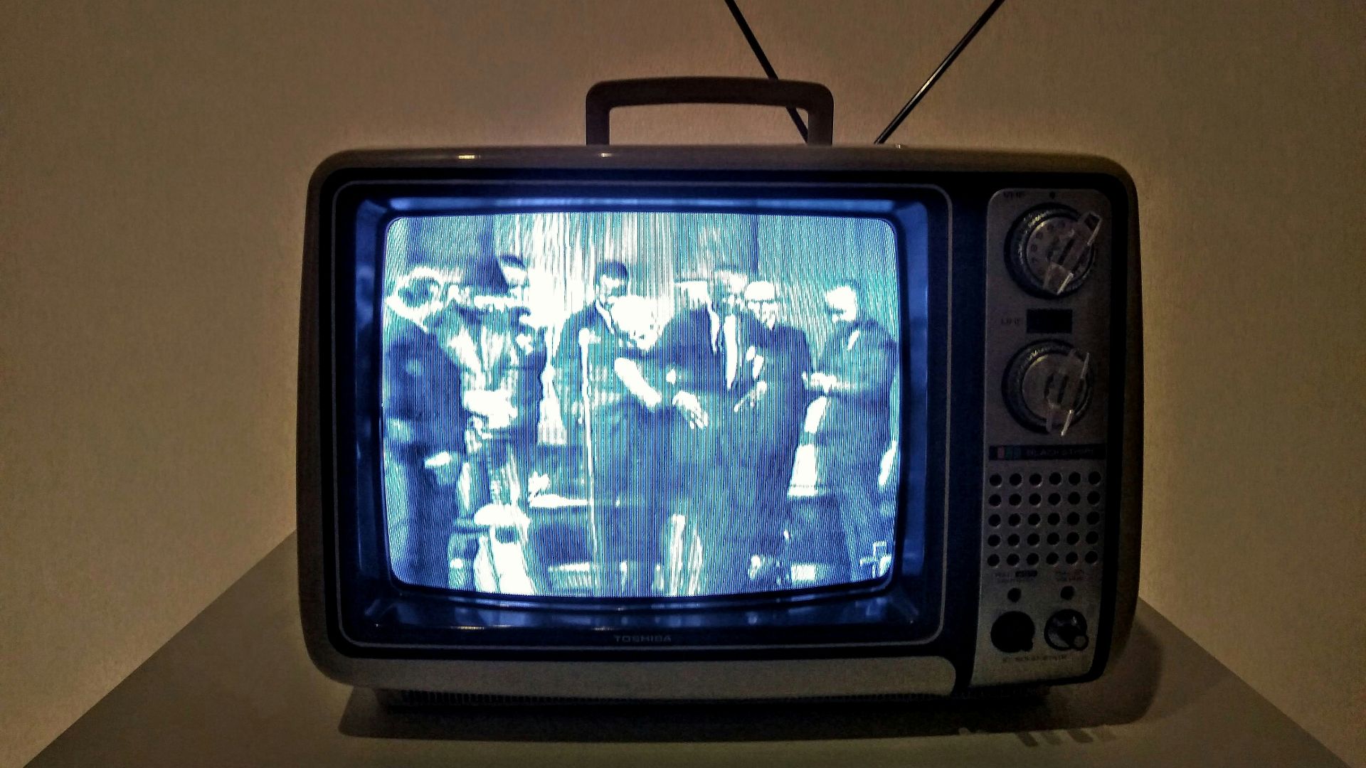 black crt tv turned on on white table