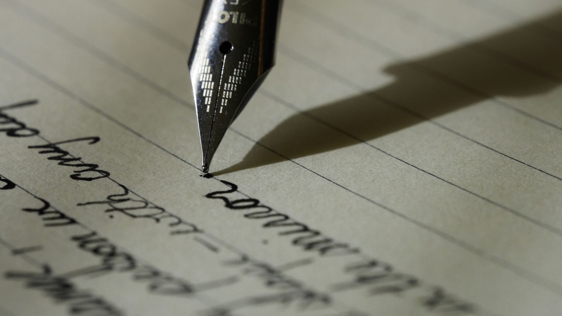fountain pen on black lined paper
