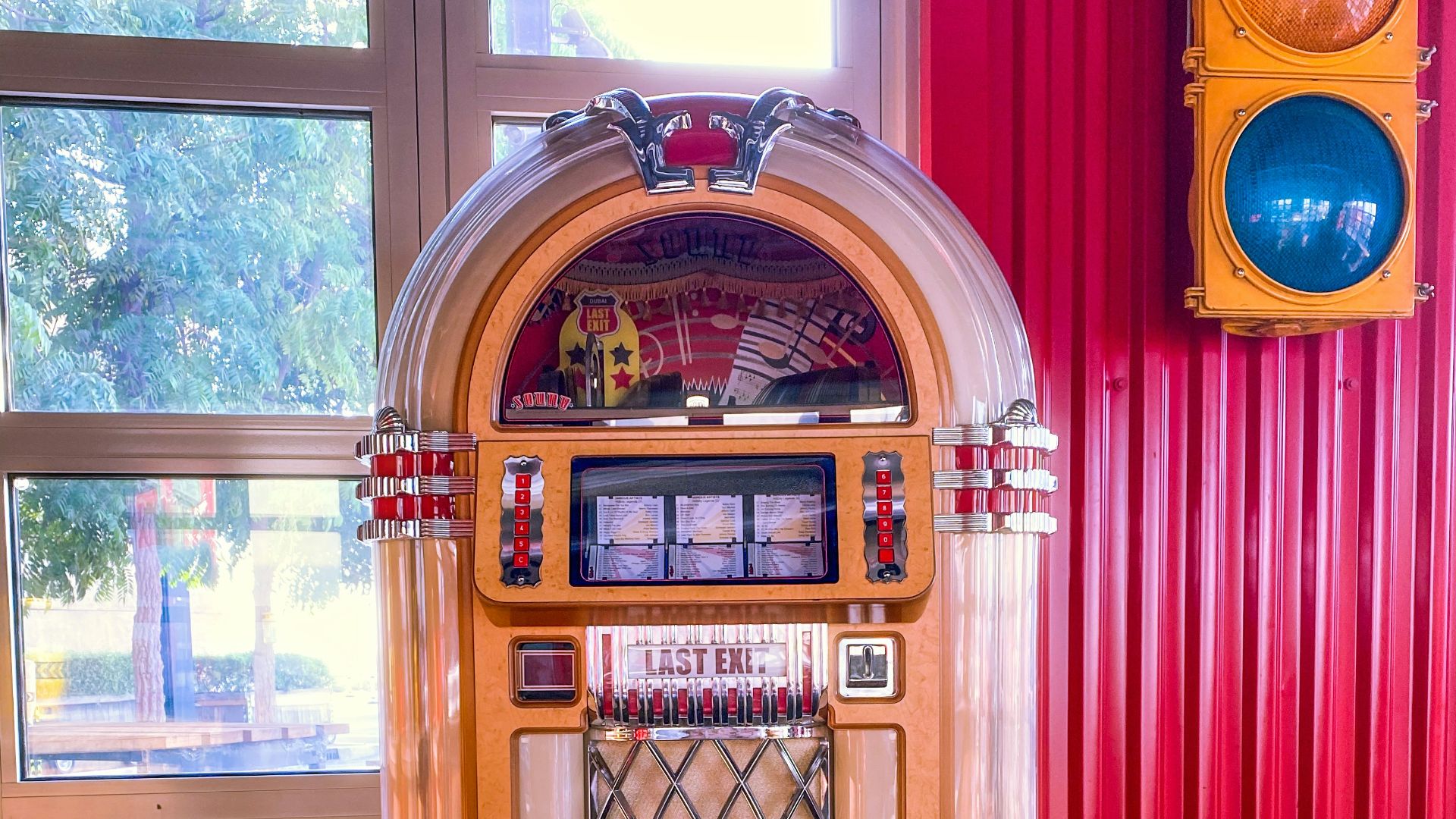a jukebox sitting in front of a window next to a traffic light