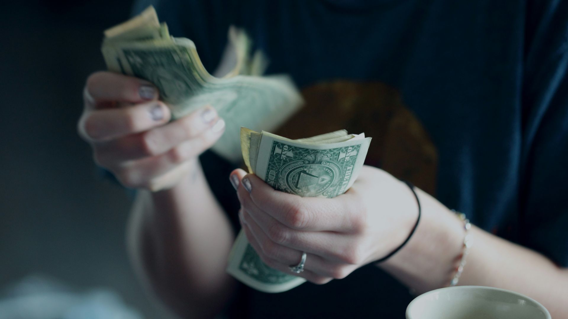 focus photography of person counting dollar banknotes