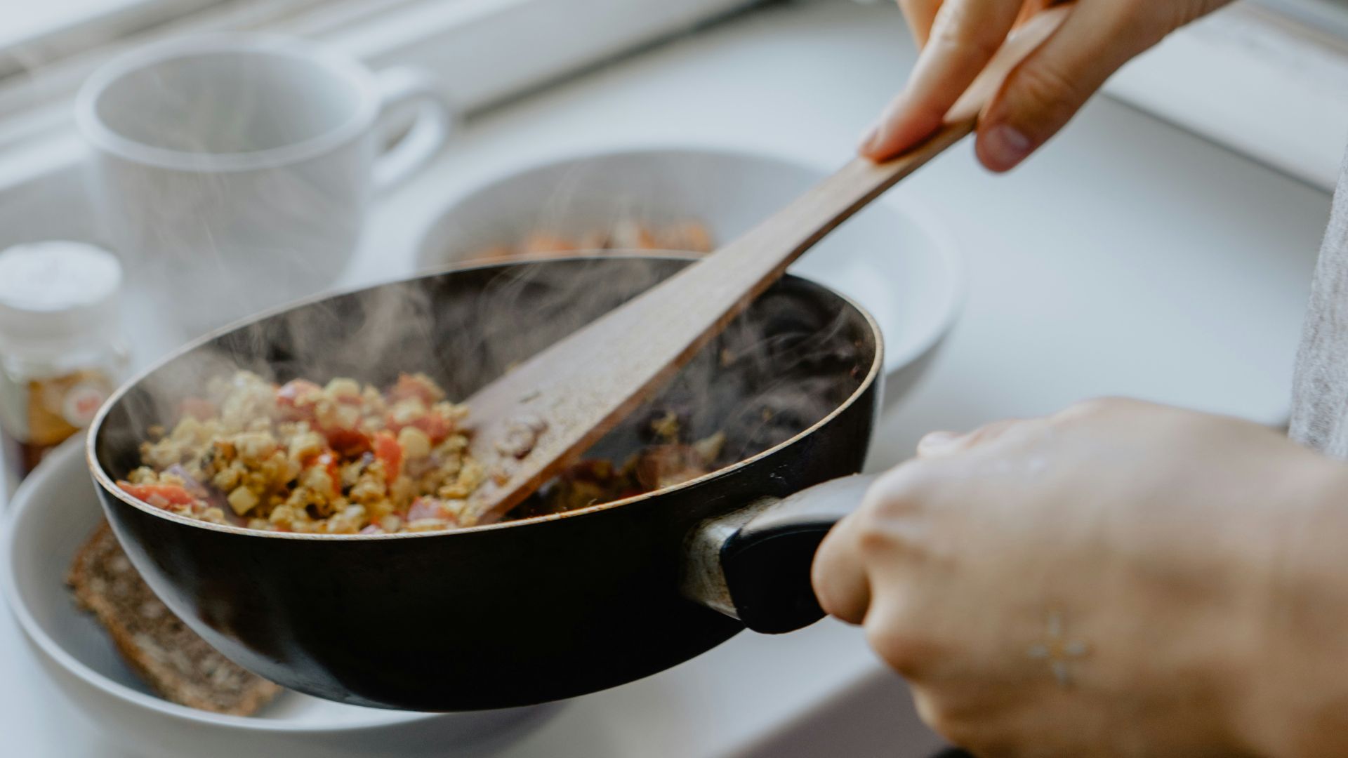 person holding black frying pan