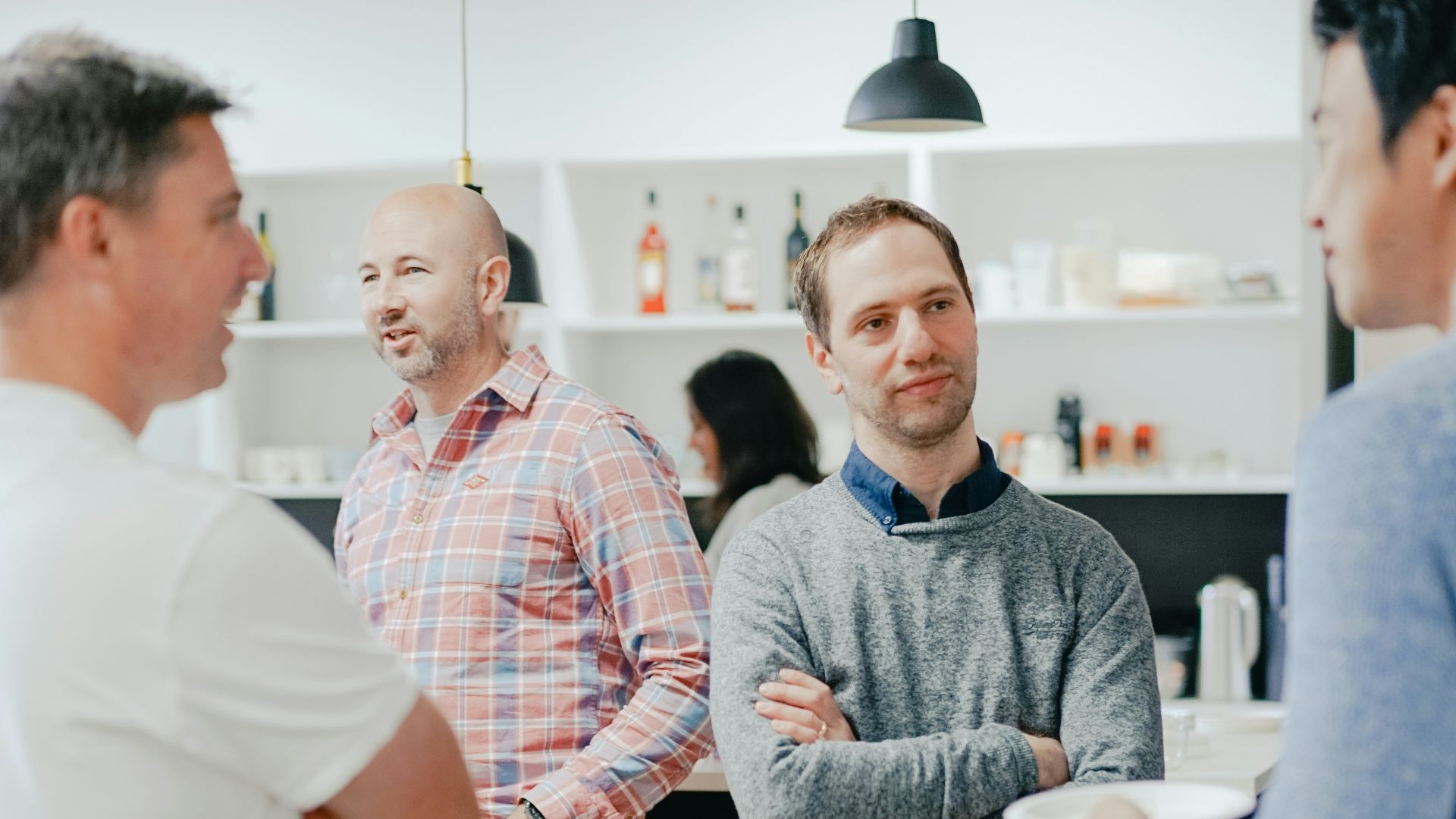 a group of men standing around a kitchen