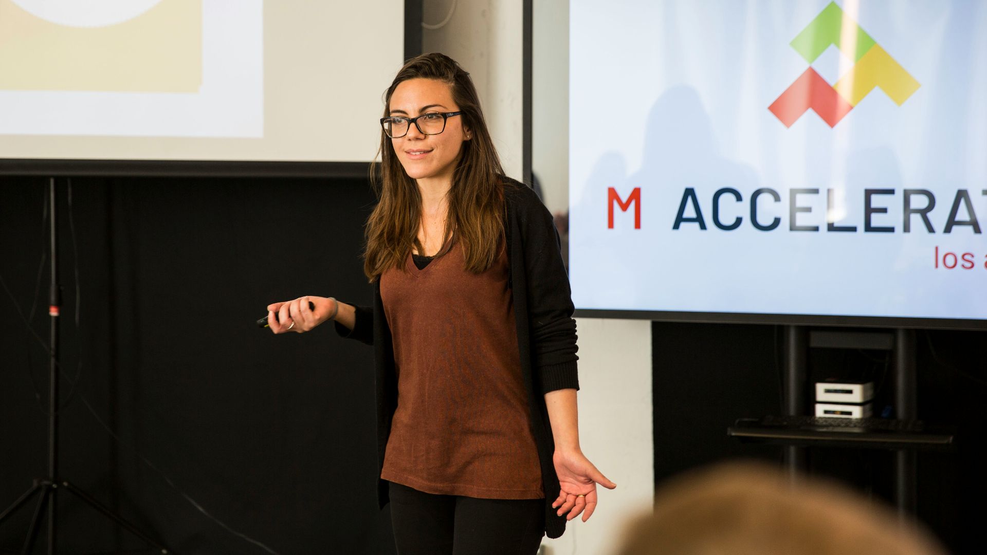 a woman standing in front of a projection screen