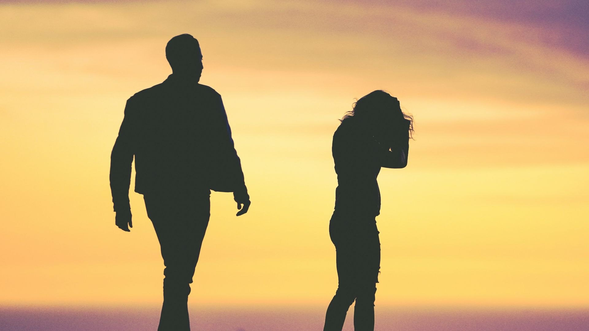 silhouette of man and woman under yellow sky