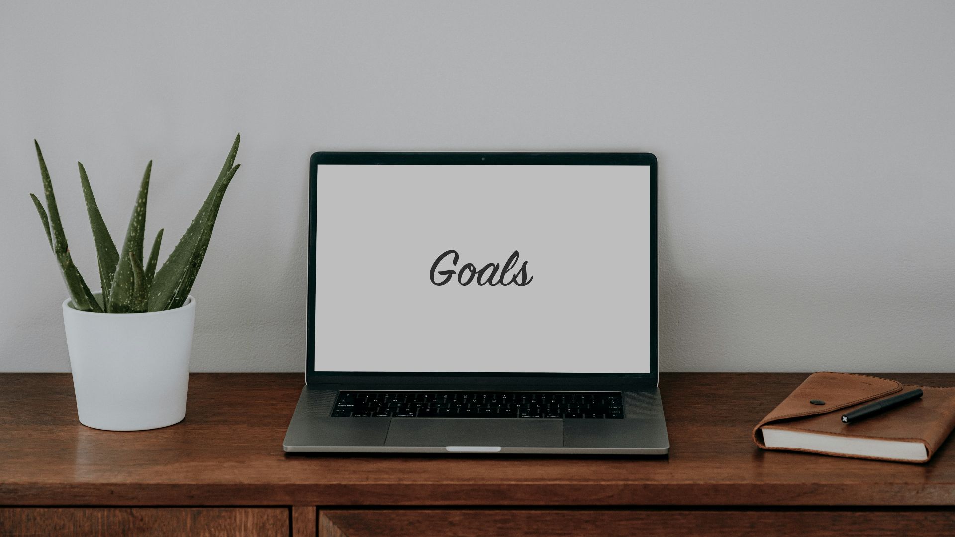 a laptop computer sitting on top of a wooden desk