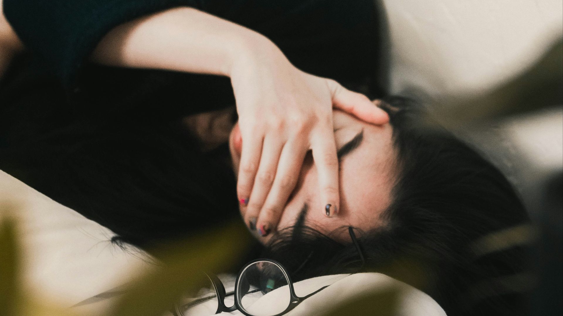 woman in black long sleeve shirt covering her face
