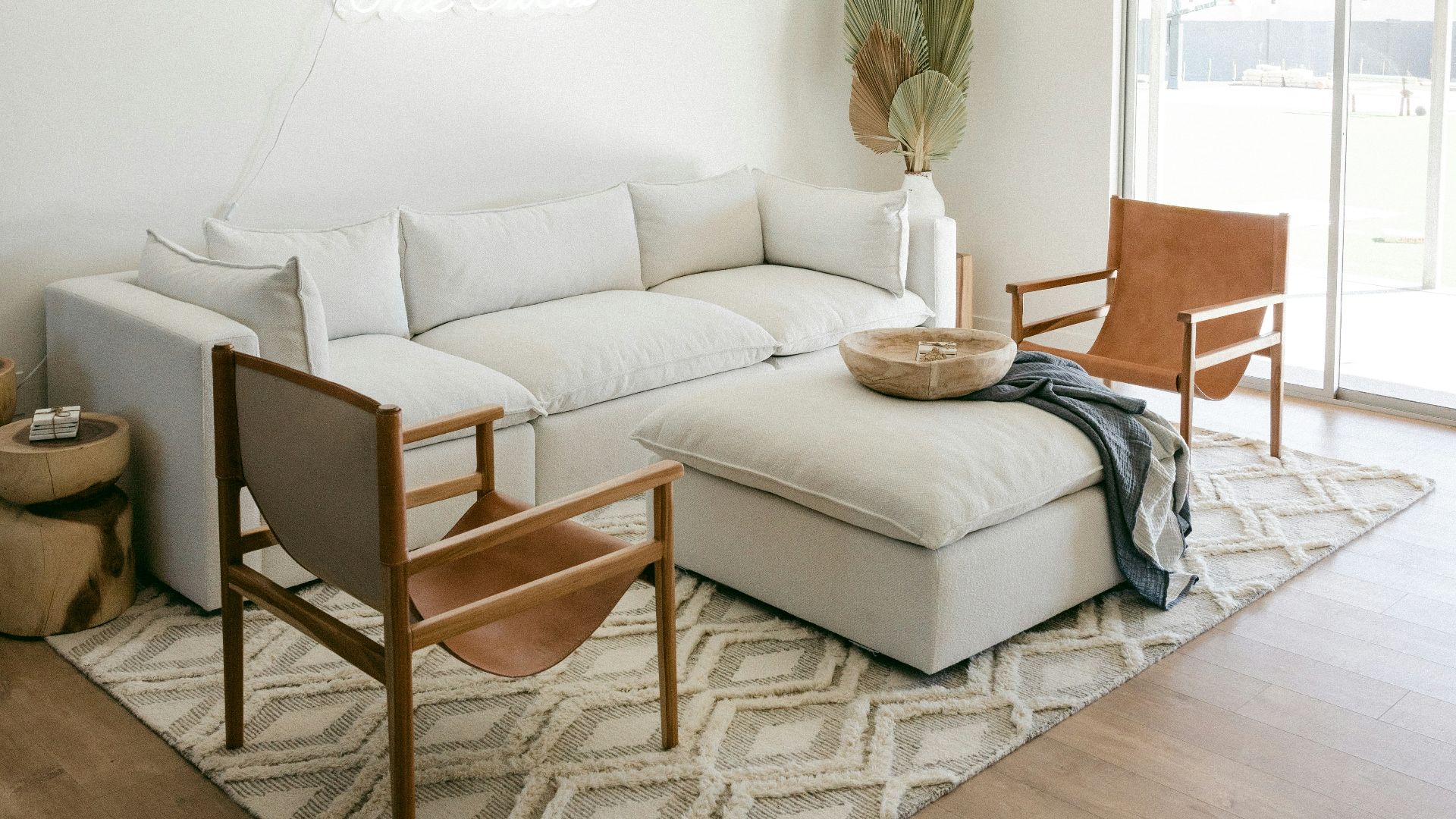 white sofa near brown wooden chair
