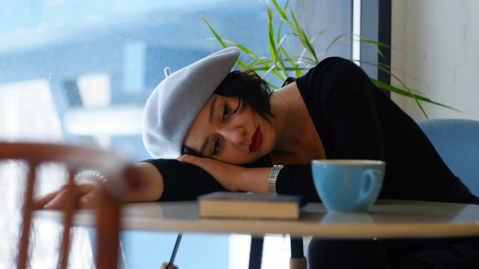 woman in black long sleeve shirt lying on white wooden table