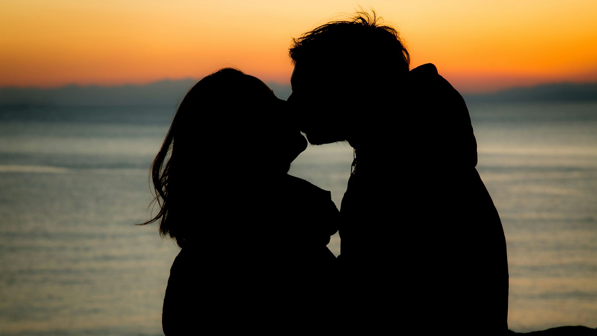 silhouette of couple kissing during sunset