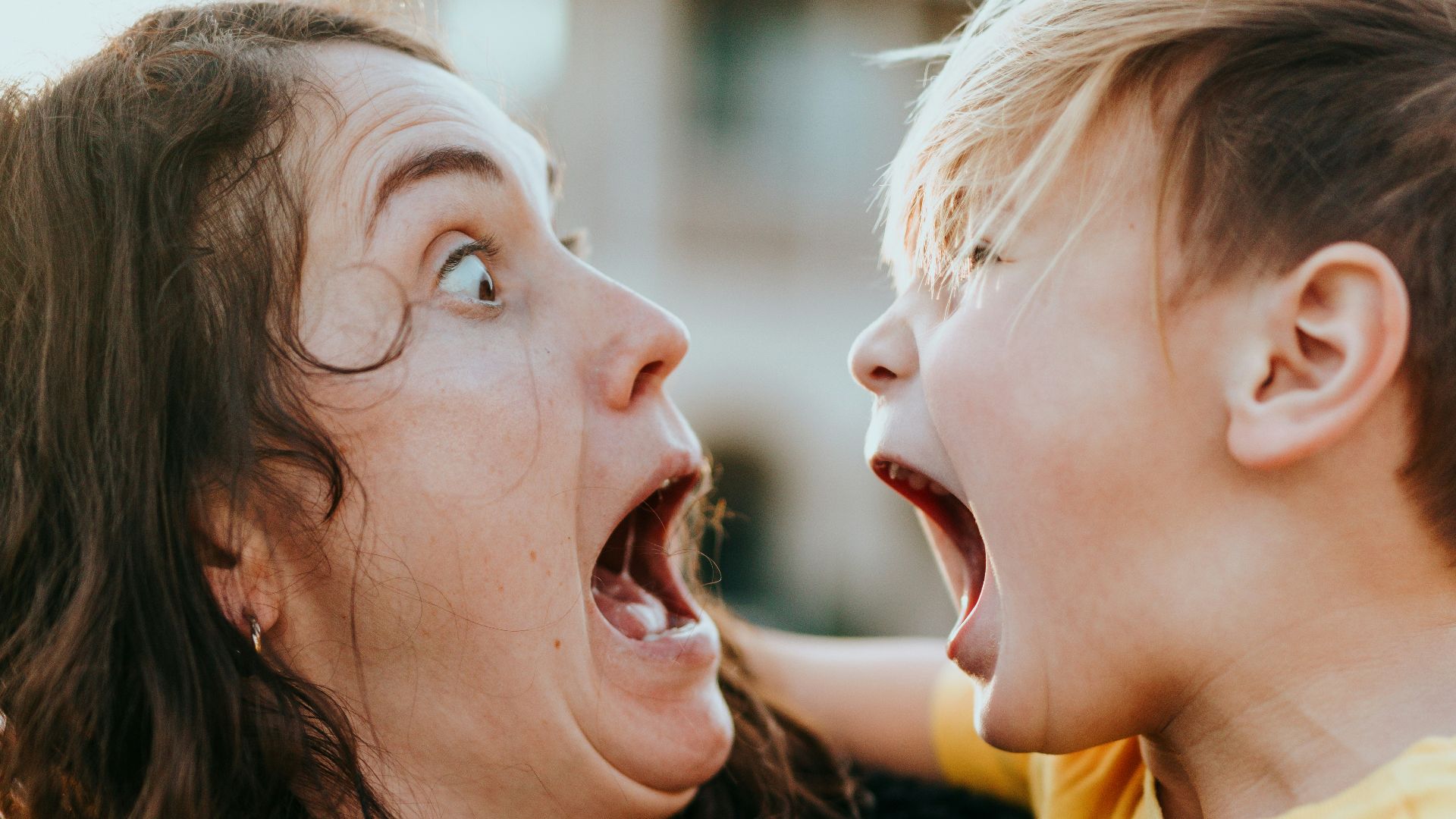 woman in black sweater kissing girl in yellow shirt