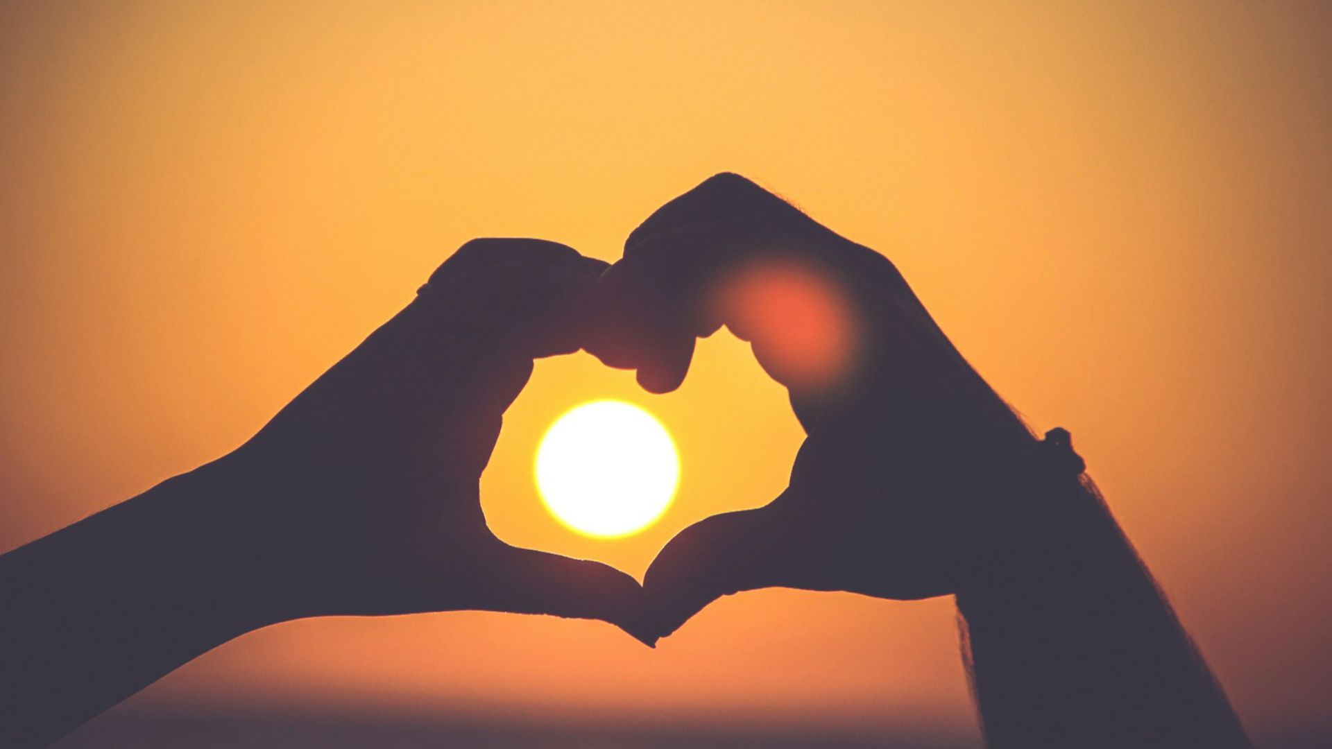 silhouette of person's hands forming heart