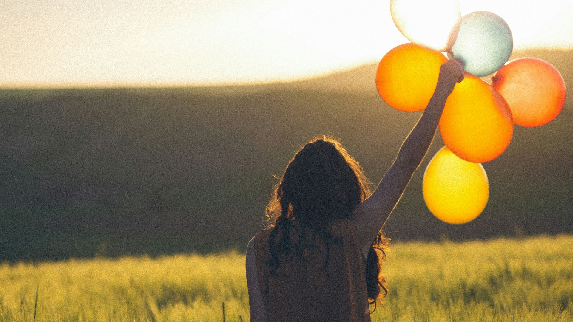 unknown person holding balloons outdoors
