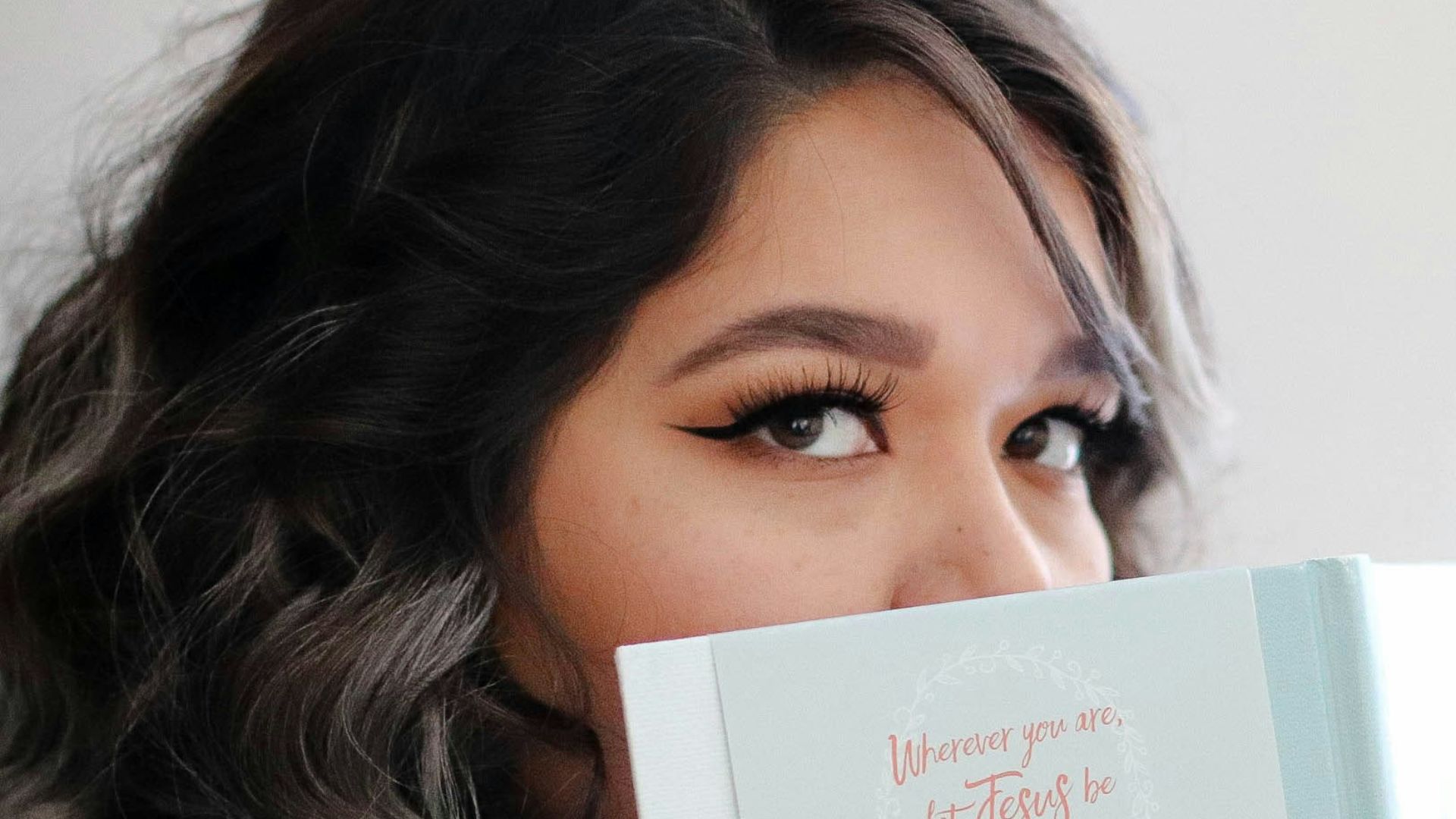 woman covering her face with book