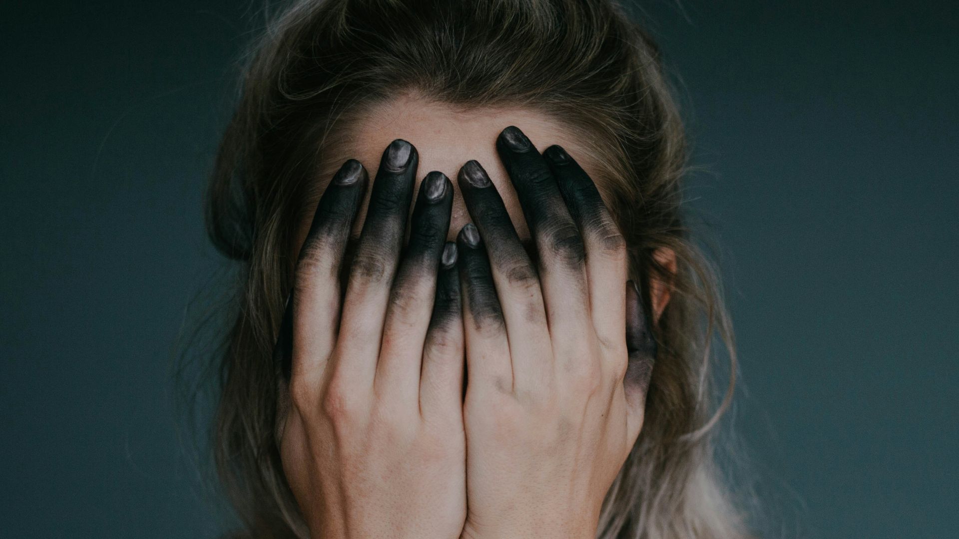 woman covering face with both hands closeup photography