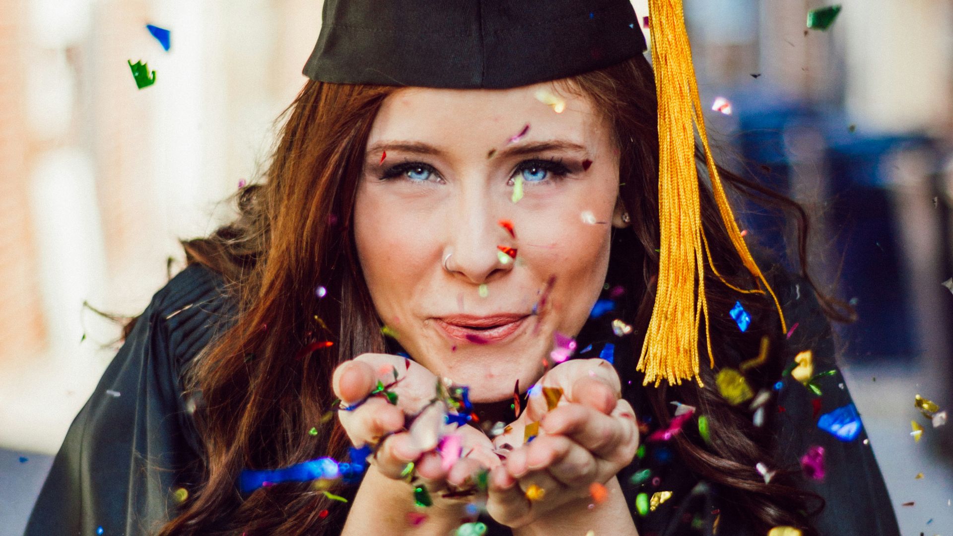 woman blowing assorted color confettis