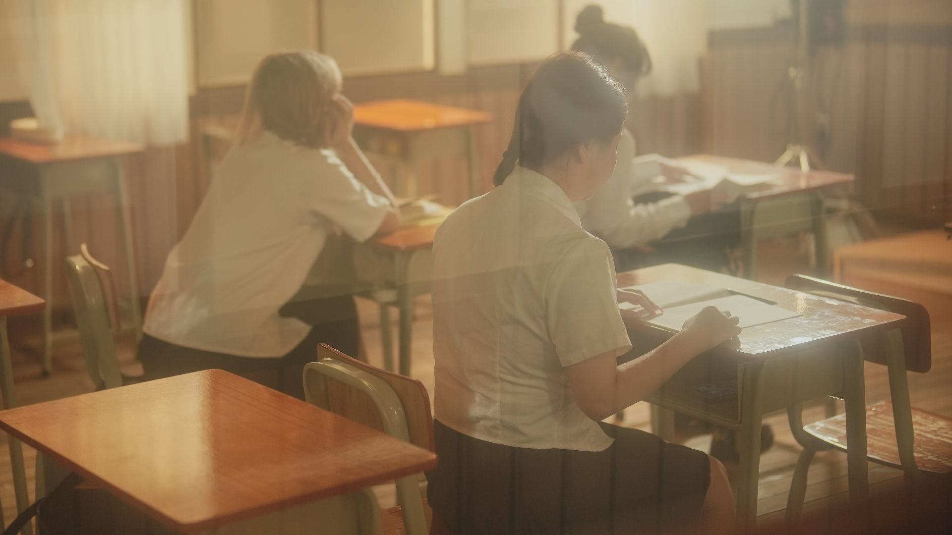 A group of people sitting at desks in a room
