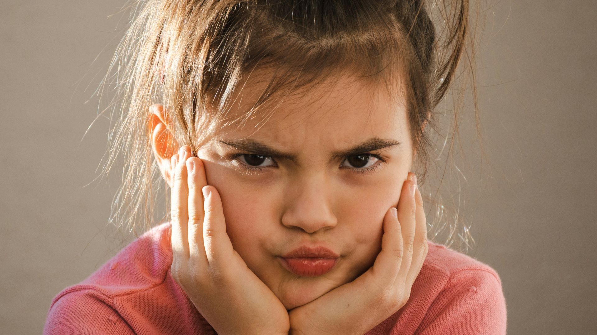 a young girl with her hands on her face