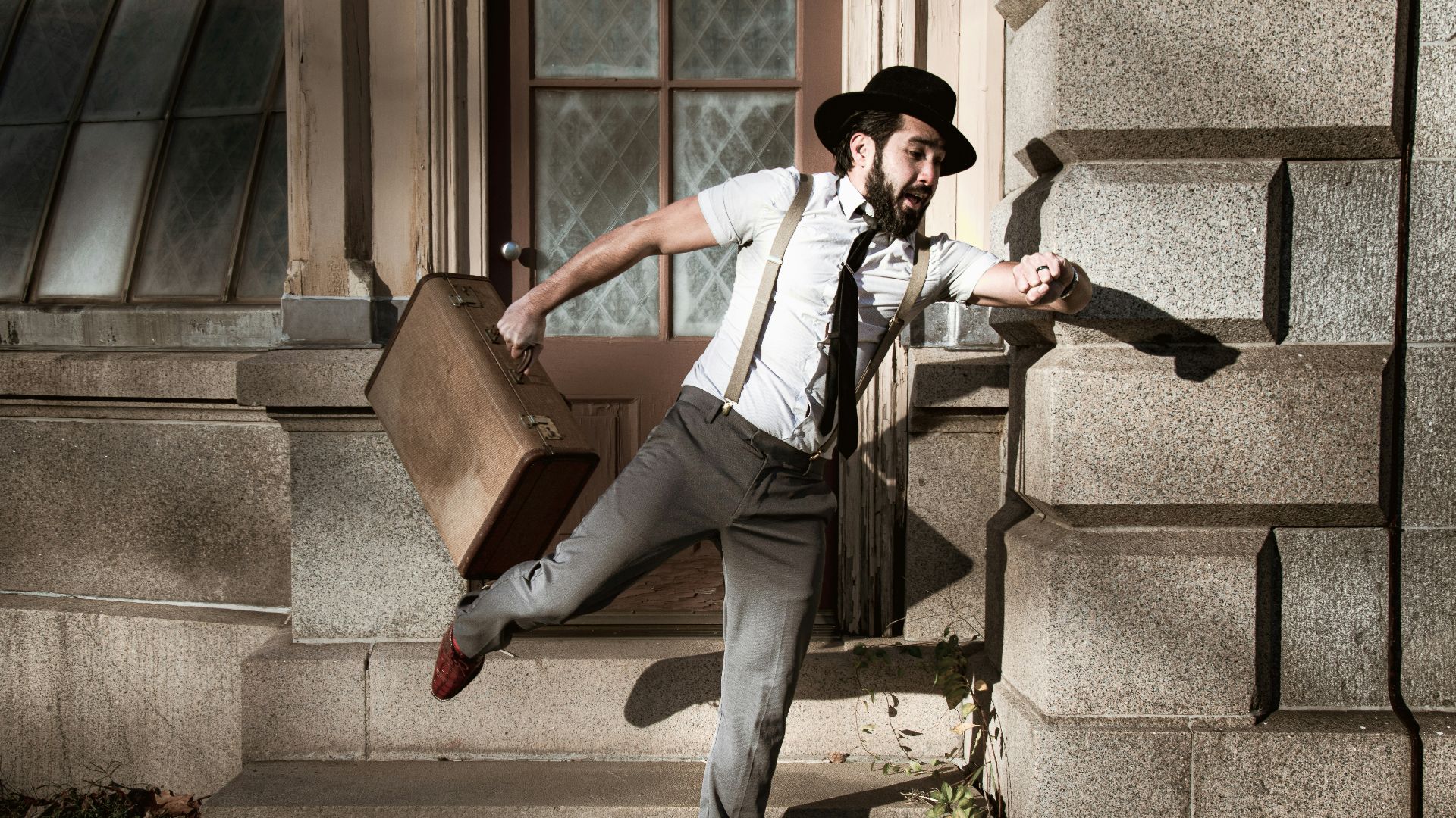 man in white dress shirt and gray pants sitting on gray concrete stairs