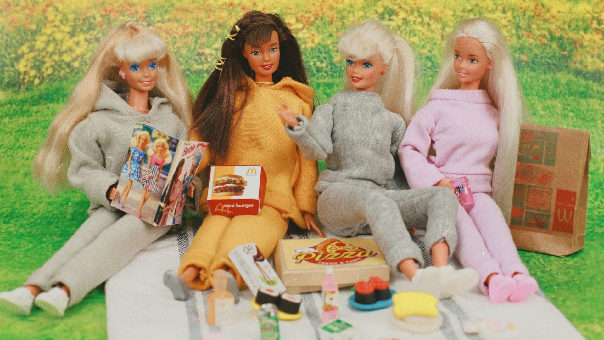A group of dolls sitting on top of a blanket