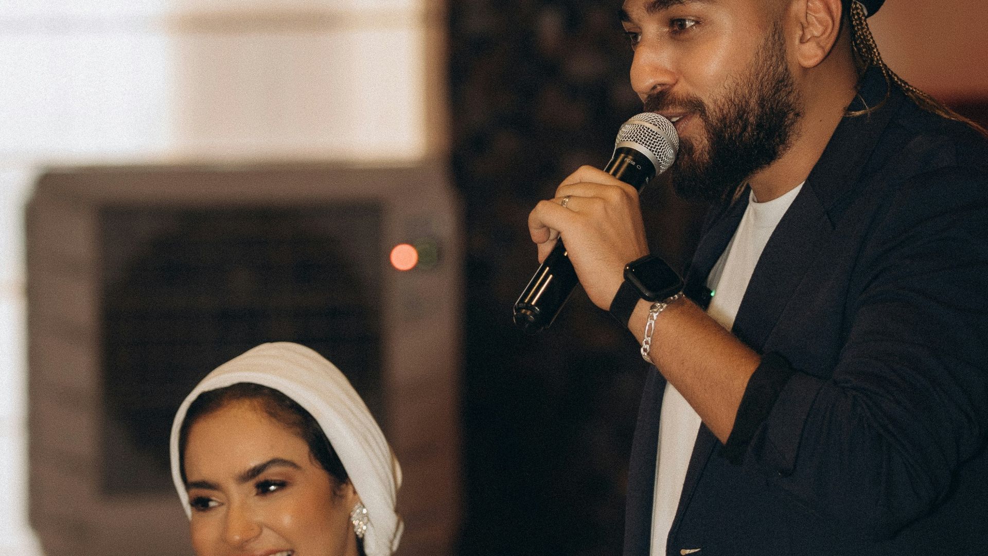 a man standing next to a woman holding a microphone