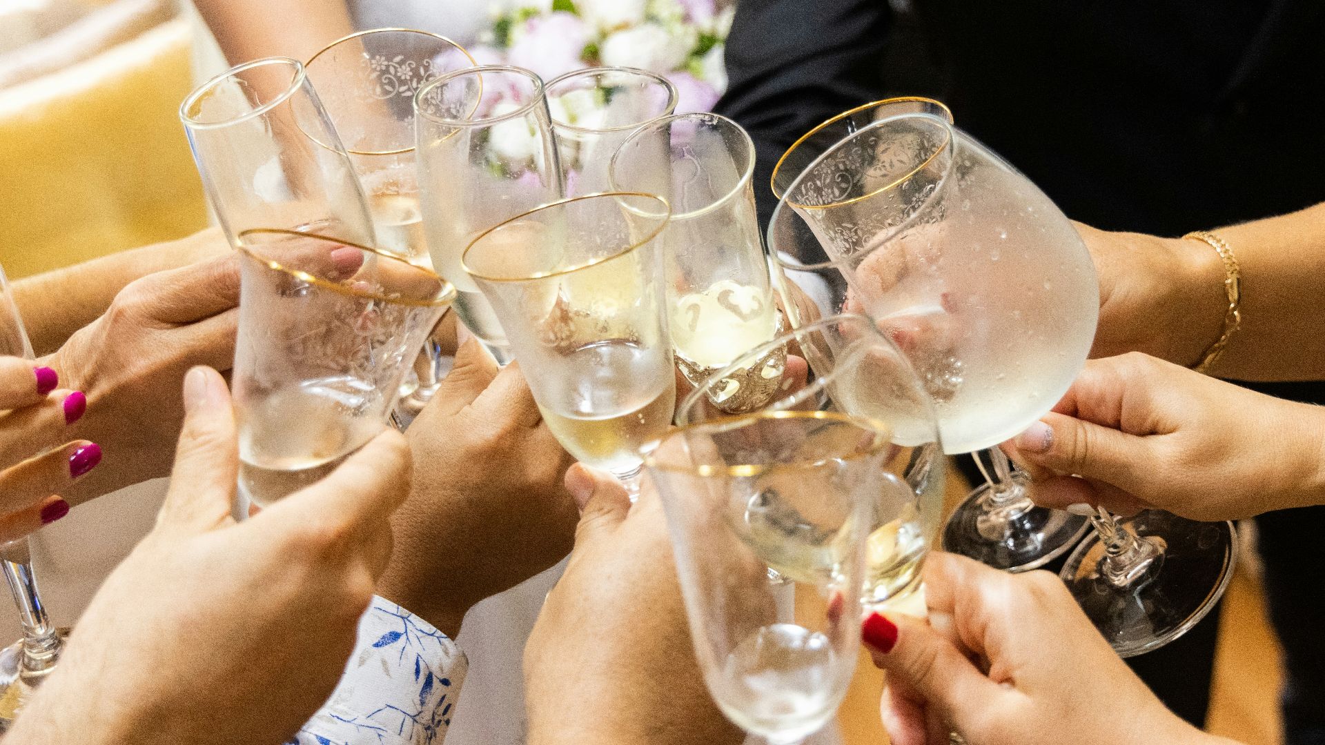 woman in white wedding dress holding clear wine glass