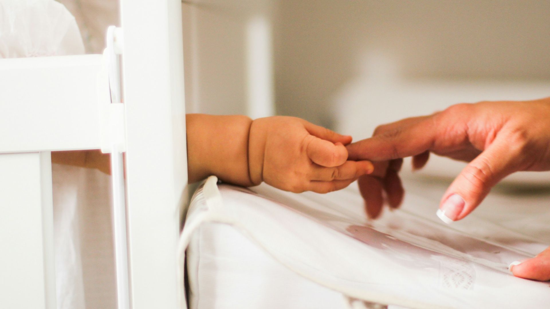person holding white textile on white table